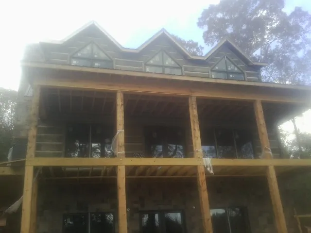 Dormers and porch framing on a large log home under construction — Roof Coating work by our crew in Selinsgrove