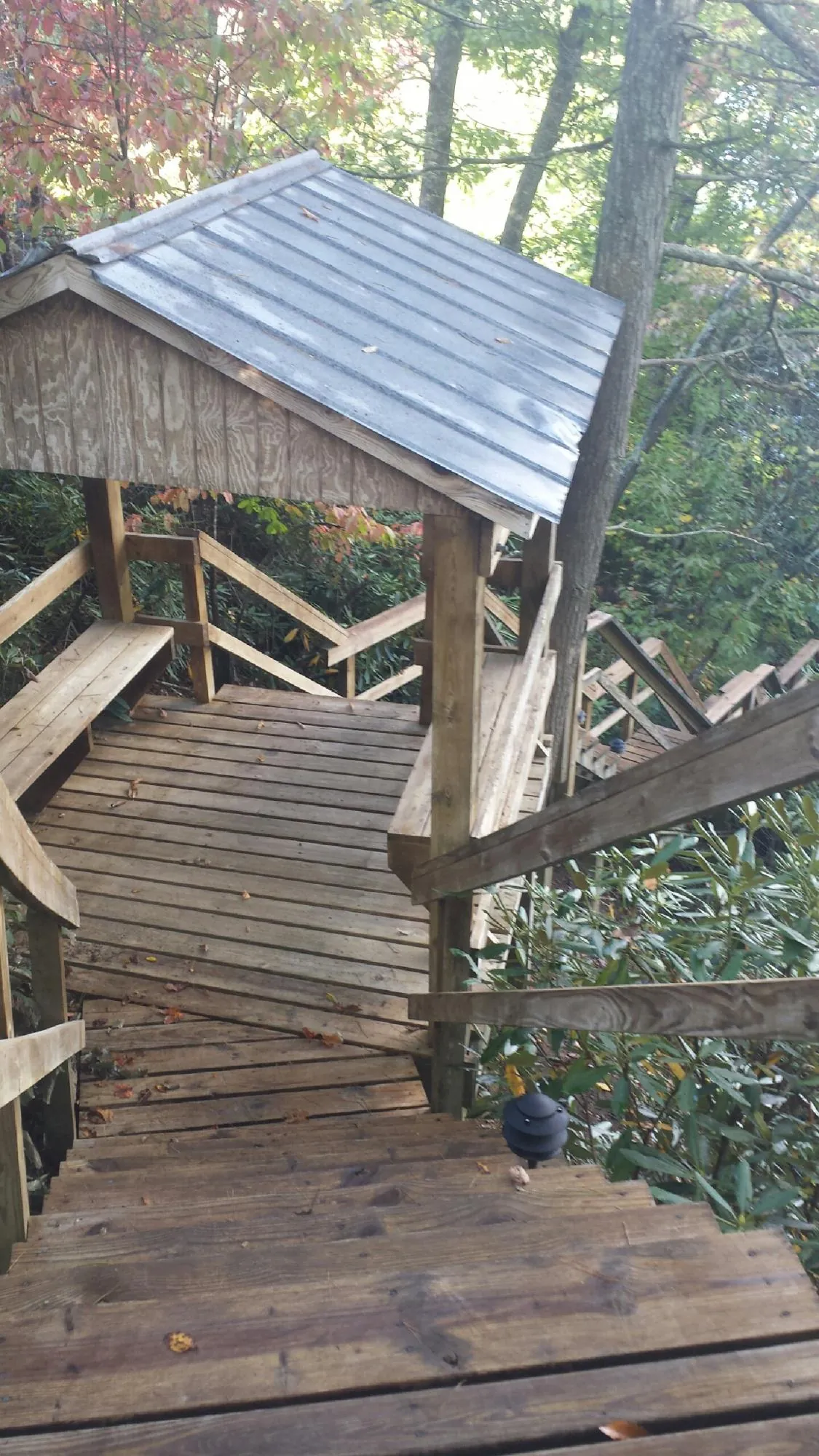 Metal roofed shelter over wooden steps on a wooded walkway — Skylight Repair & Installation work by our crew in Selinsgrove
